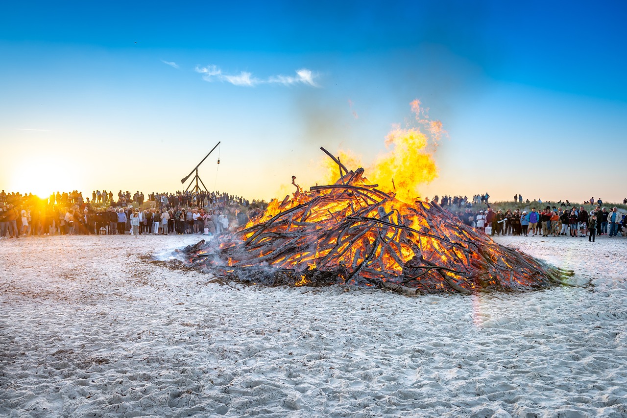 Sankt Hans bål på strand med Skagen vippefyr i baggrunden